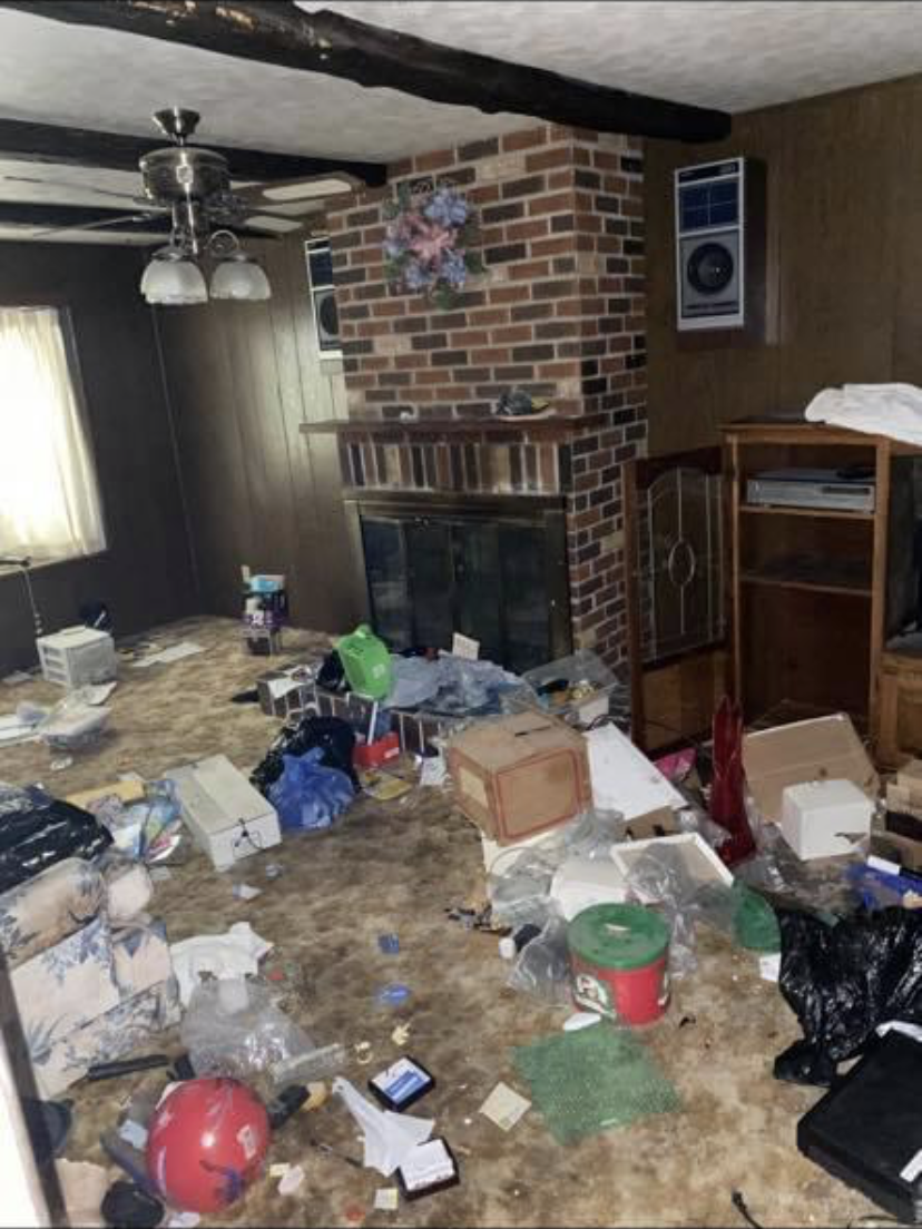 Before — distressed living room with brick fireplace
