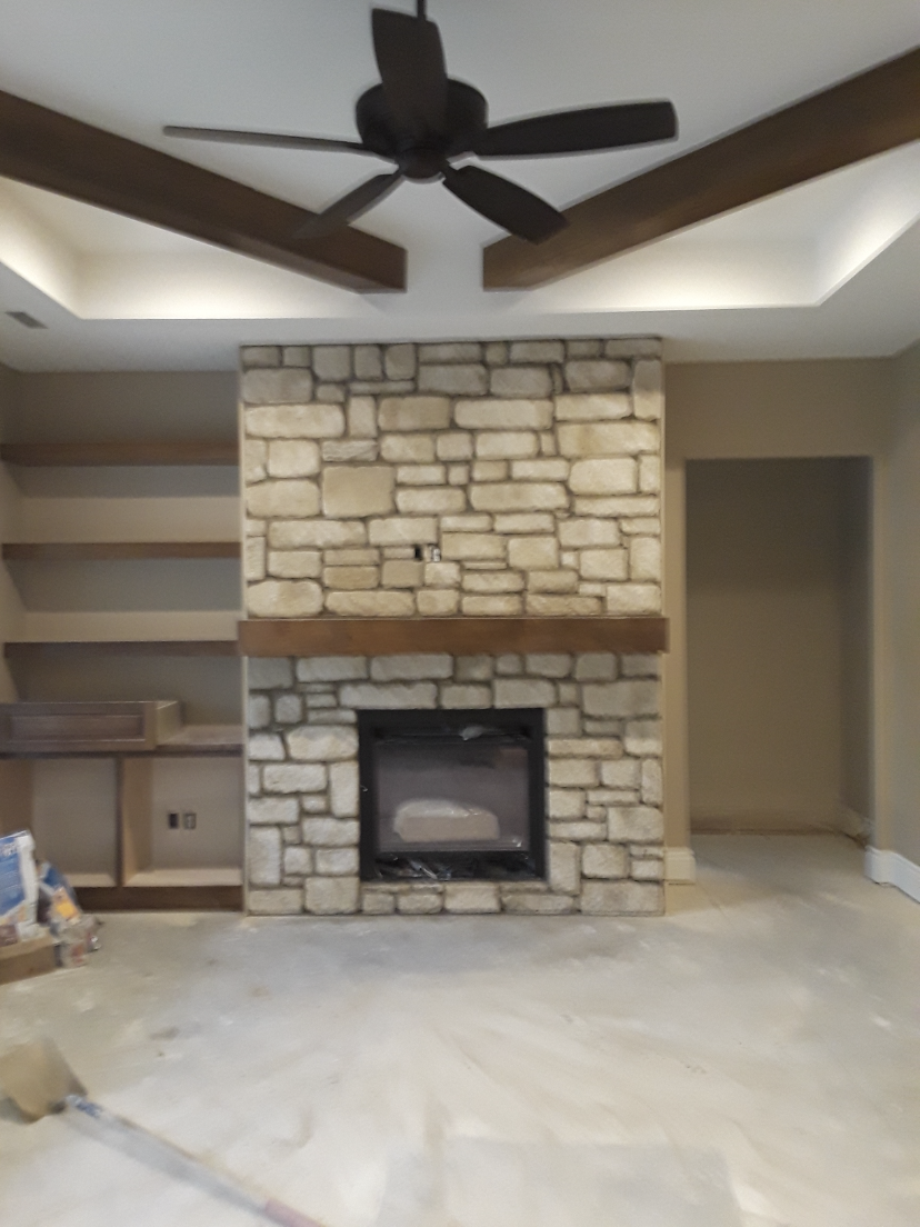 Vaulted ceiling with ceiling fan and fireplace