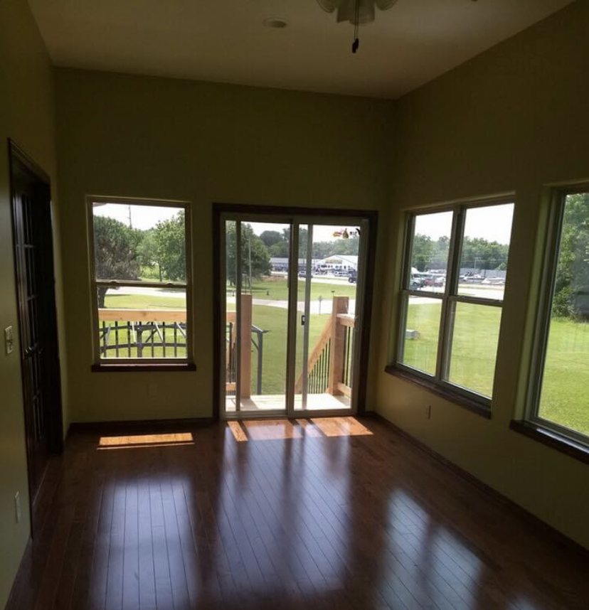 Bright finished sunroom with hardwood floors and large windows