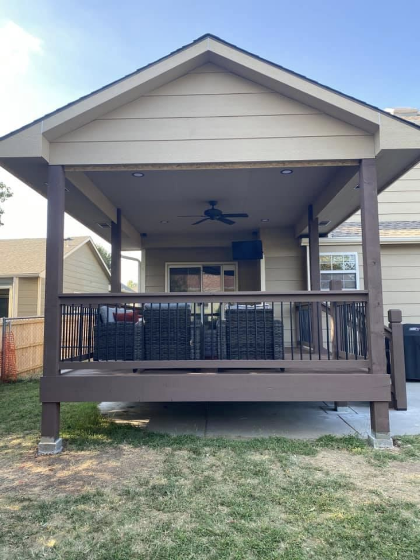 After — completed covered deck with ceiling fan and railing
