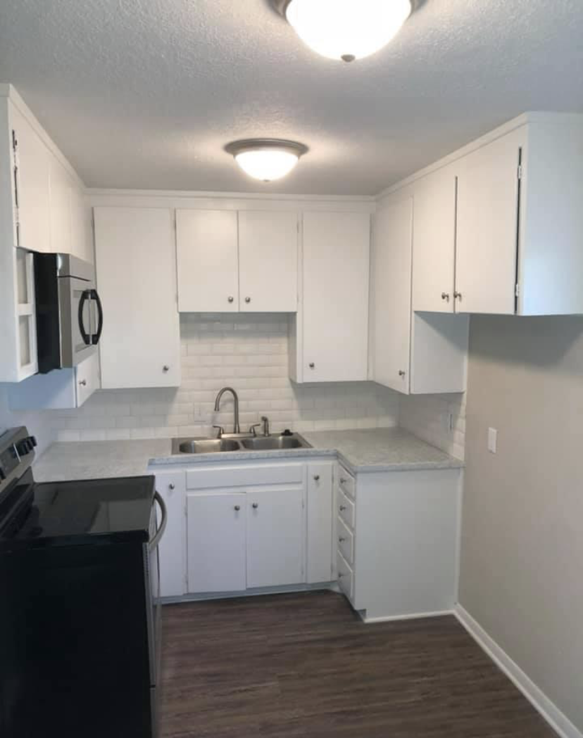 After — finished white kitchen with new cabinetry and appliances
