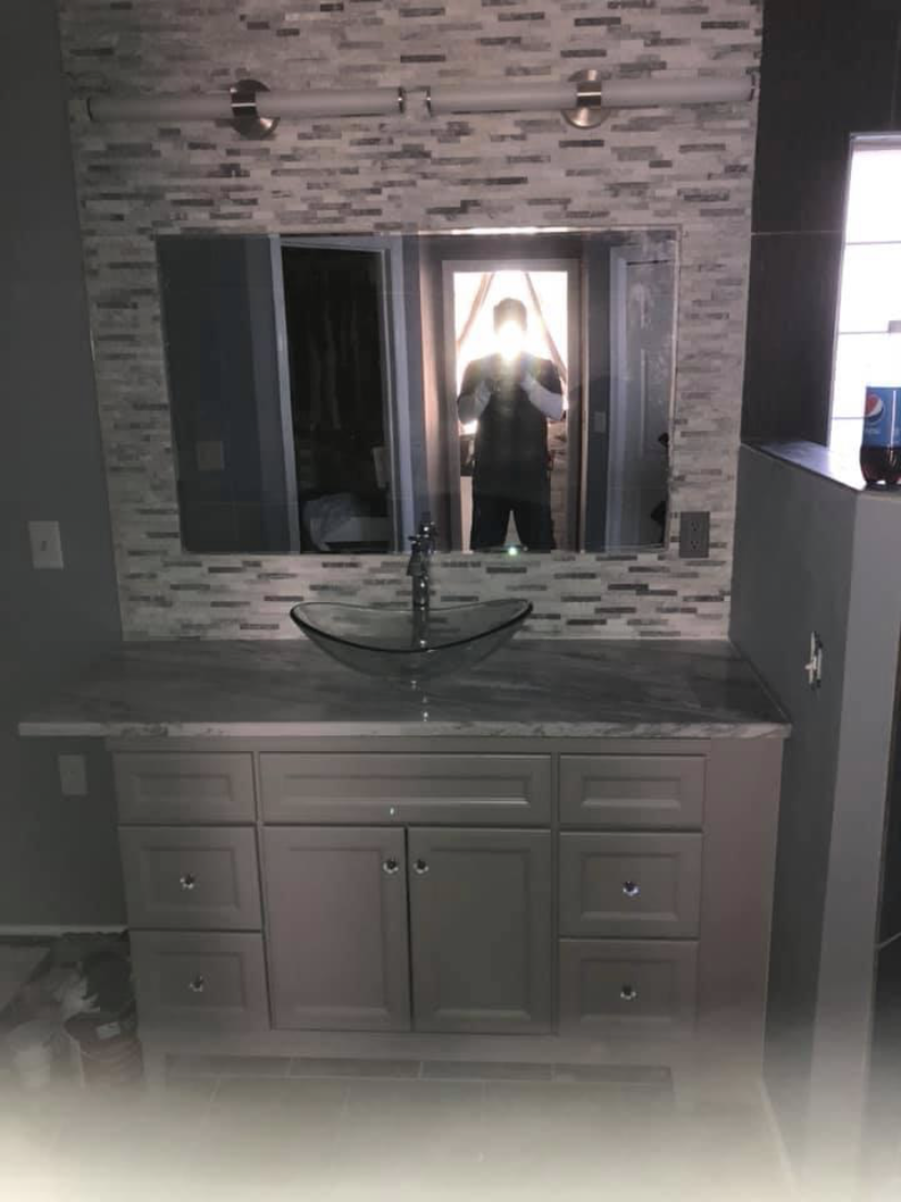 Completed bathroom with marble tile and dark vanity
