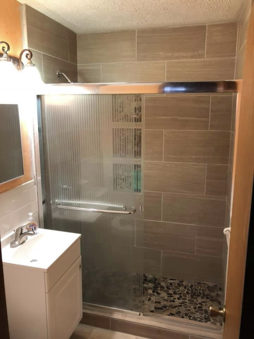 Glass shower enclosure with large format tile and mosaic floor