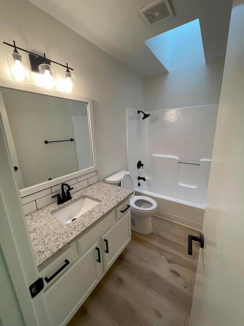 Completed bathroom with skylight and marble tile