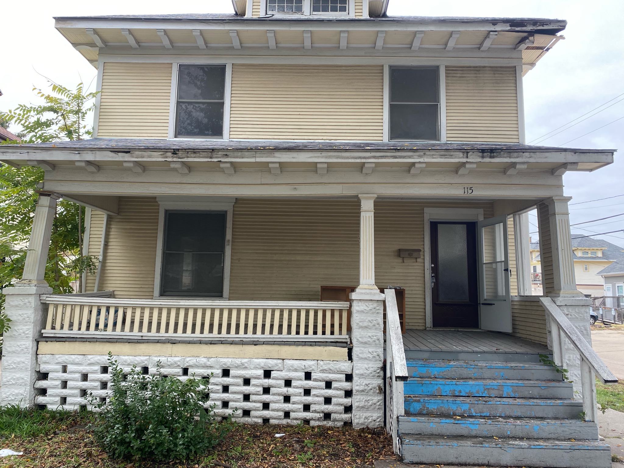 Before — original deteriorated house exterior