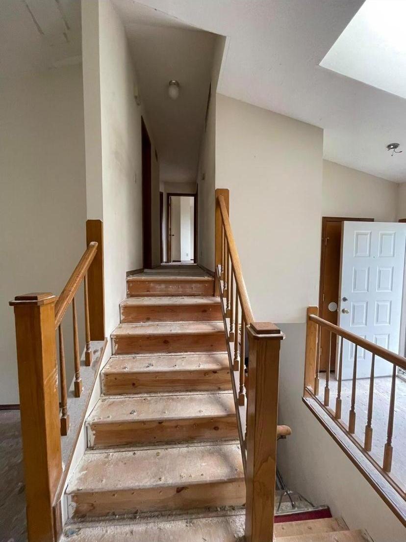 Finished staircase with wood handrails and painted walls